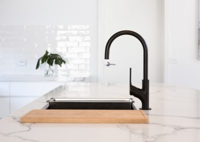Monochrome kitchen detail of black gooseneck tap