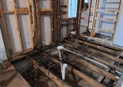 Stripped back framing with exposed plumbing and floor joists during home renovation at Main Beach