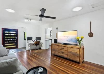 Open-plan lounge with timber floors, ceiling fan and study nook before home renovation at Main Beach