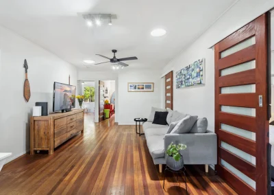 Living area with polished timber floors and pivot front door before home renovation at Main Beach