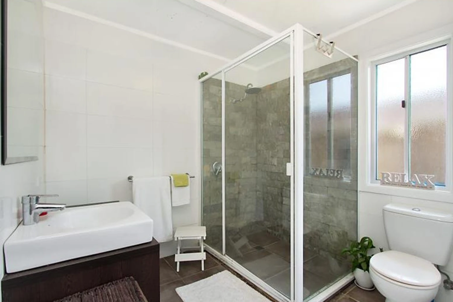 Old bathroom with framed shower screen, bath combo and worn tiles before bathroom renovation at Main Beach