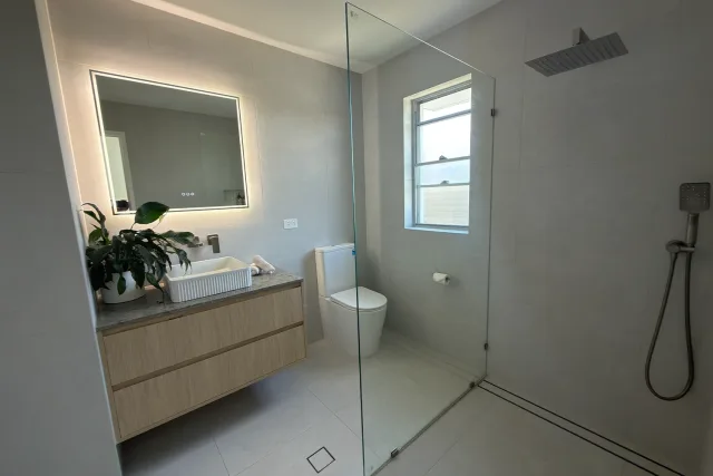 Bathroom renovation with walk-in frameless glass shower and floating vanity